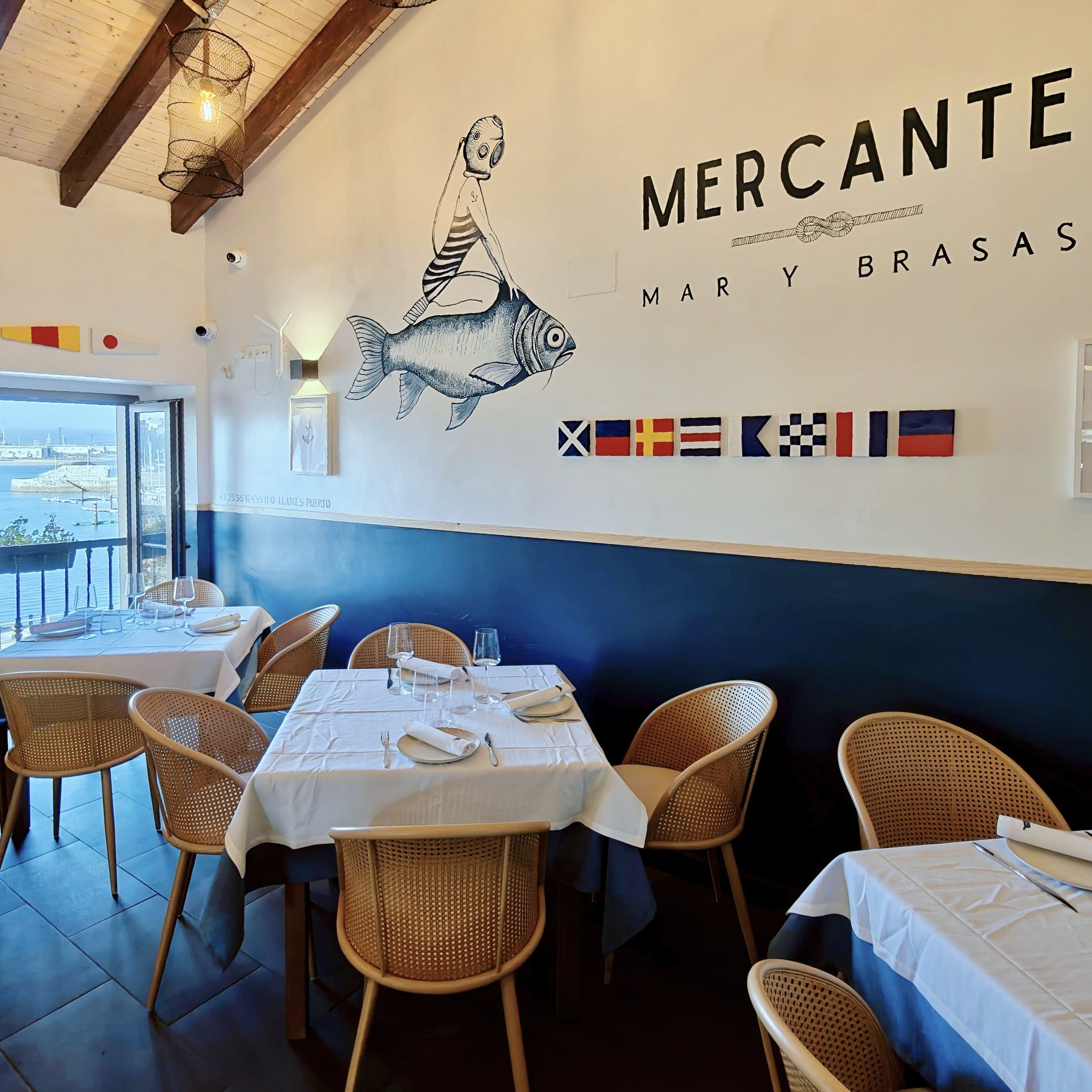 Mural náutico del Mercante con banderas de señales y ventana al puerto