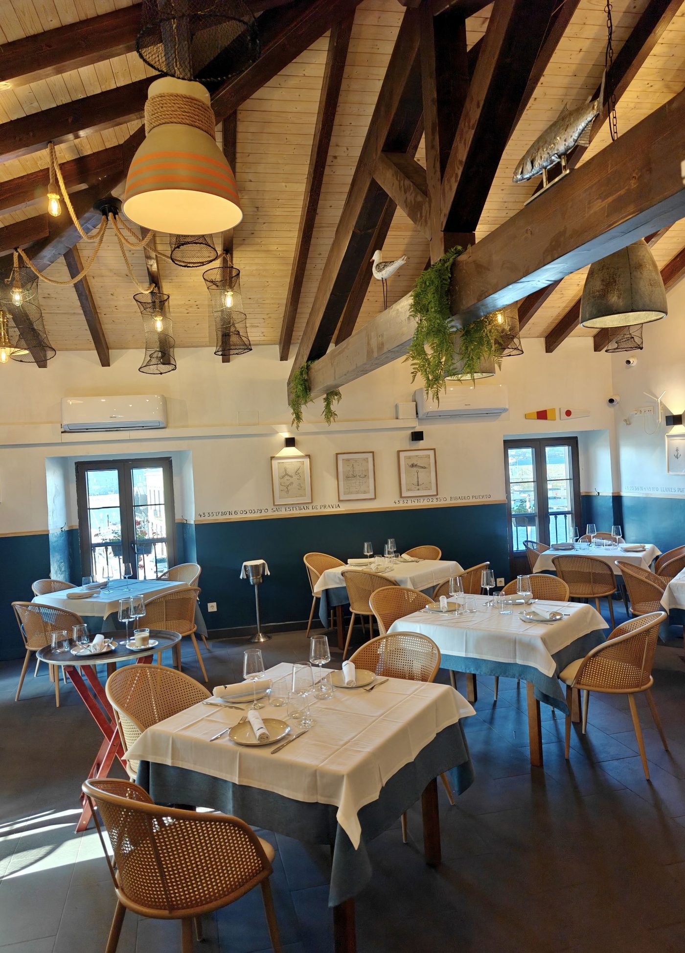 Comedor superior del Mercante con techo de madera y lámparas de pesca